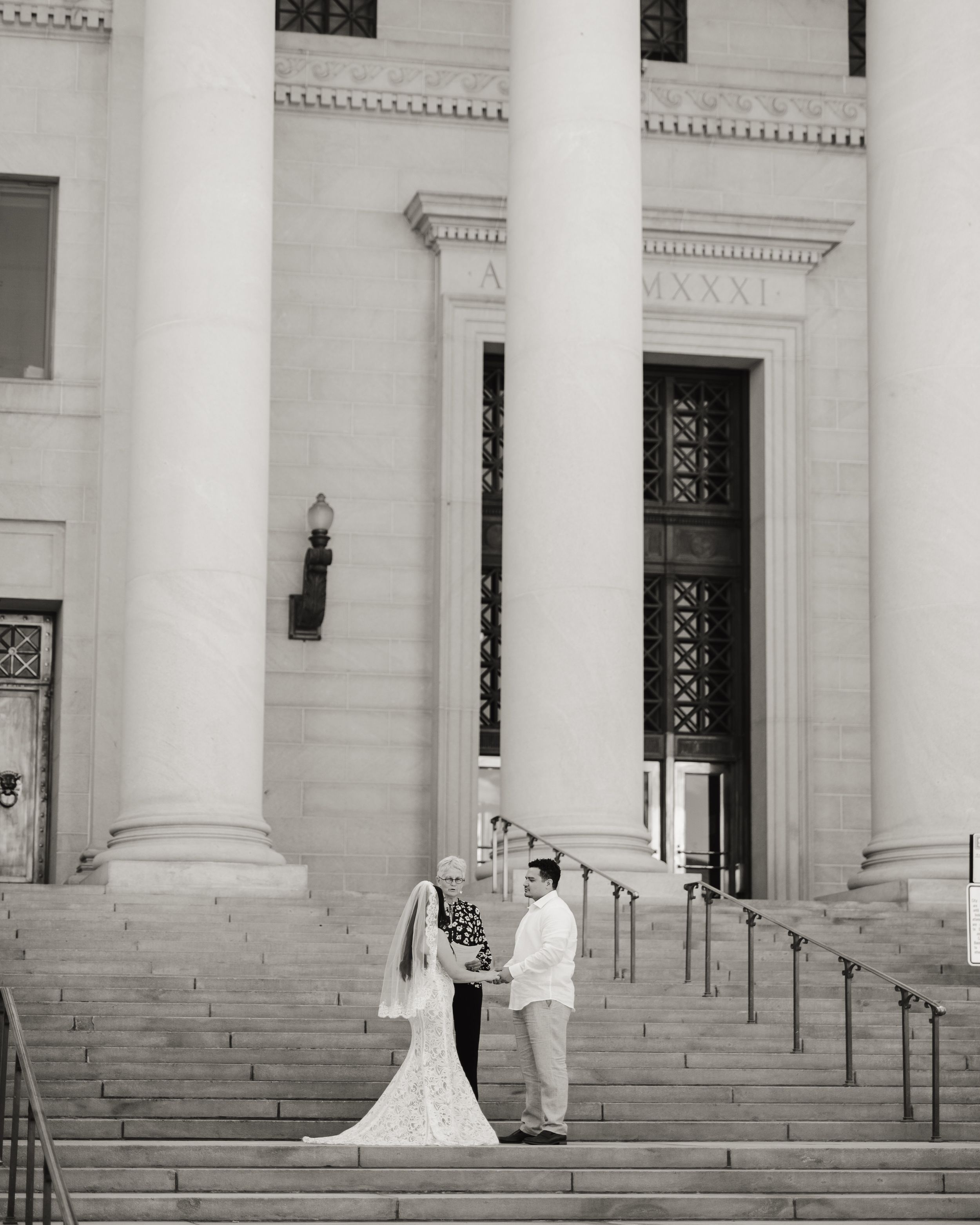 Wedding ceremony sequence on grand white stone steps of a neoclassical building with tall columns.