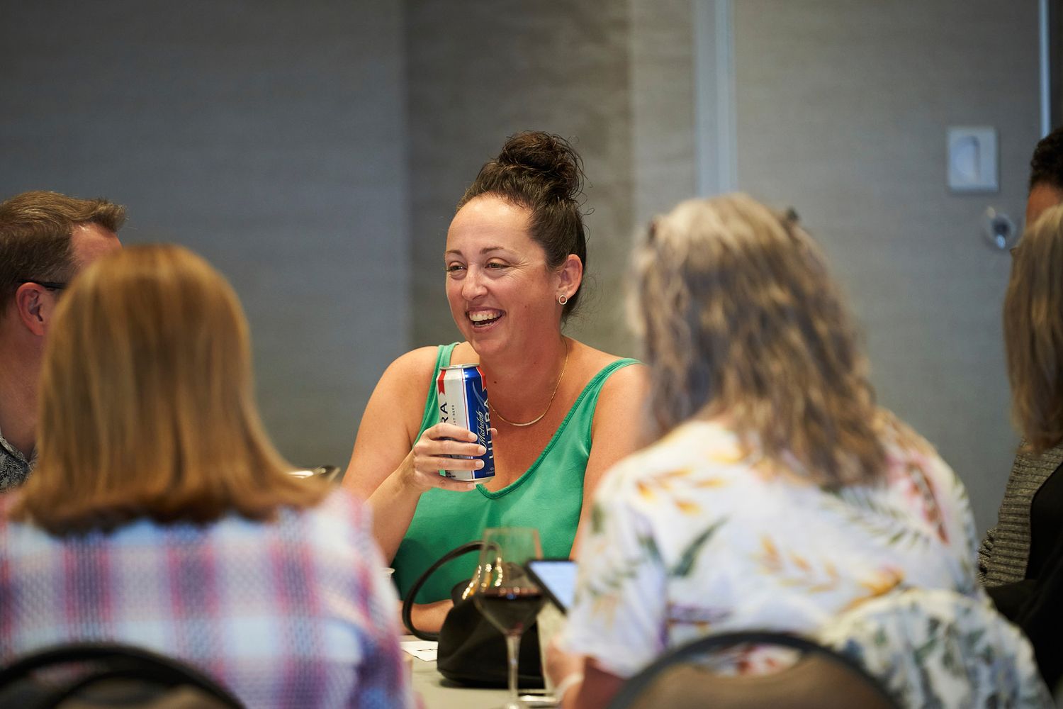 A lively group discussion during a casual meeting with attendees seated at tables.