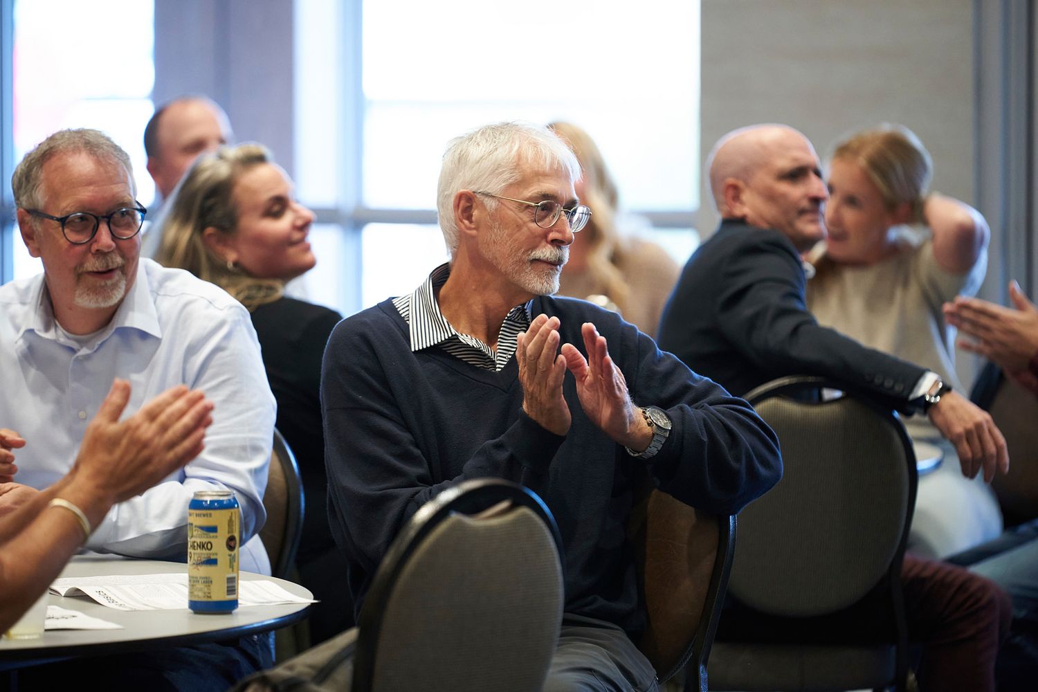 Attendees showing appreciation with applause during a professional gathering.