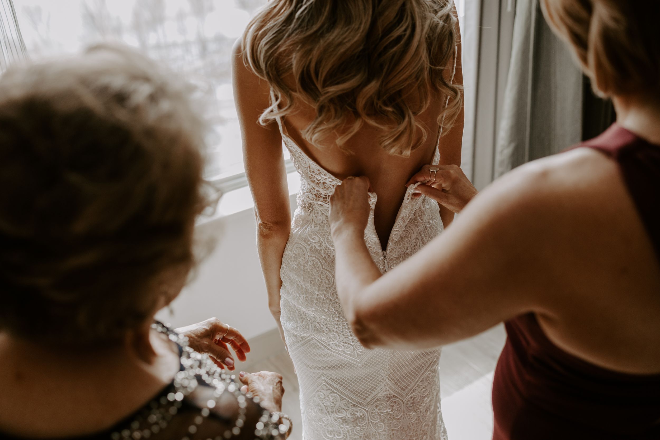 Final adjustments being made to a lace wedding dress.