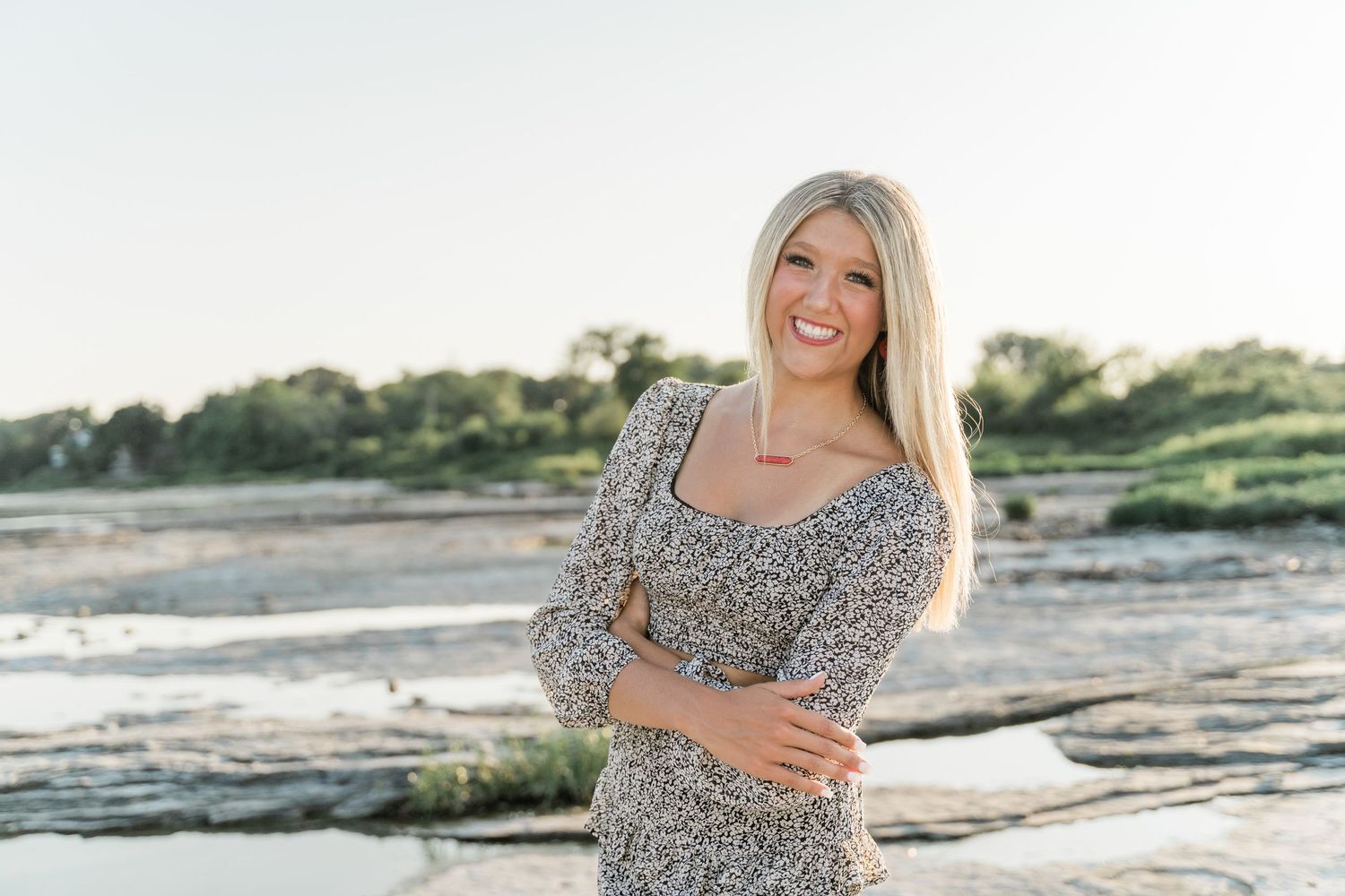 Springfield High School senior in patterned black and white outfit posing by the Maumee River at Side Cut Metropark.