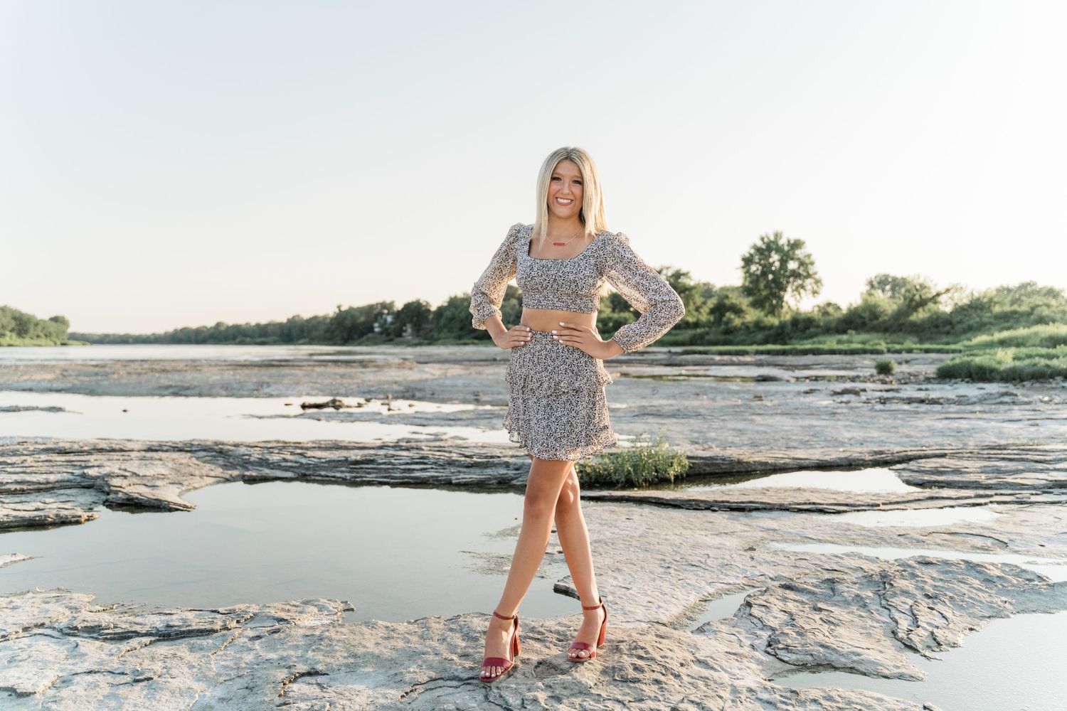 Senior striking a pose near the water in patterned separates at Side Cut Metropark in Maumee, Ohio.