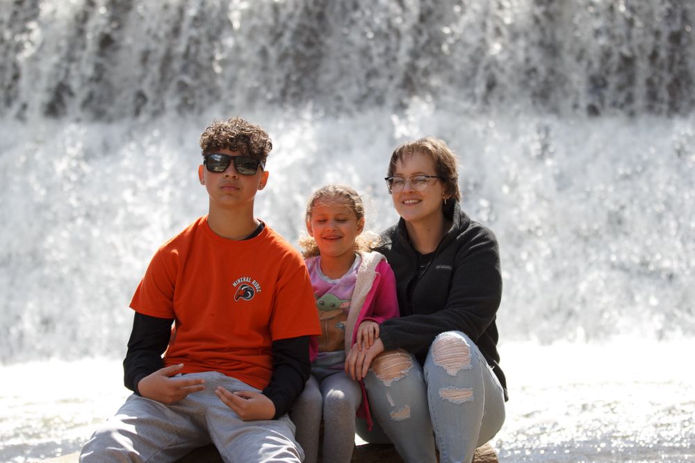 Group sitting together in front of cascading waterfall.
