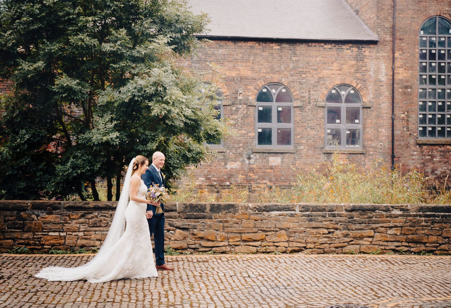 bride and groom walk the industrial cobbled streets of kelham island sheffield