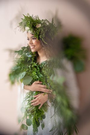 Young-lady-with-greenery-wrapped-around-her-while-she-looks-away.
