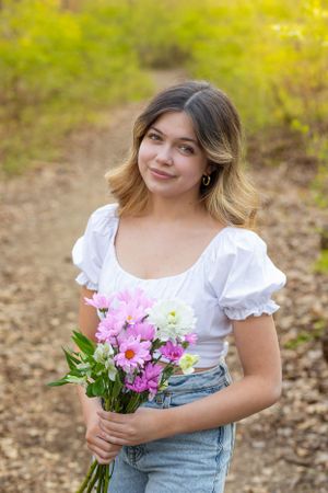 Eight-Grade-Graduate-at-a-park-in-Grand-Rapids-with-flowers-in-her-hand.
