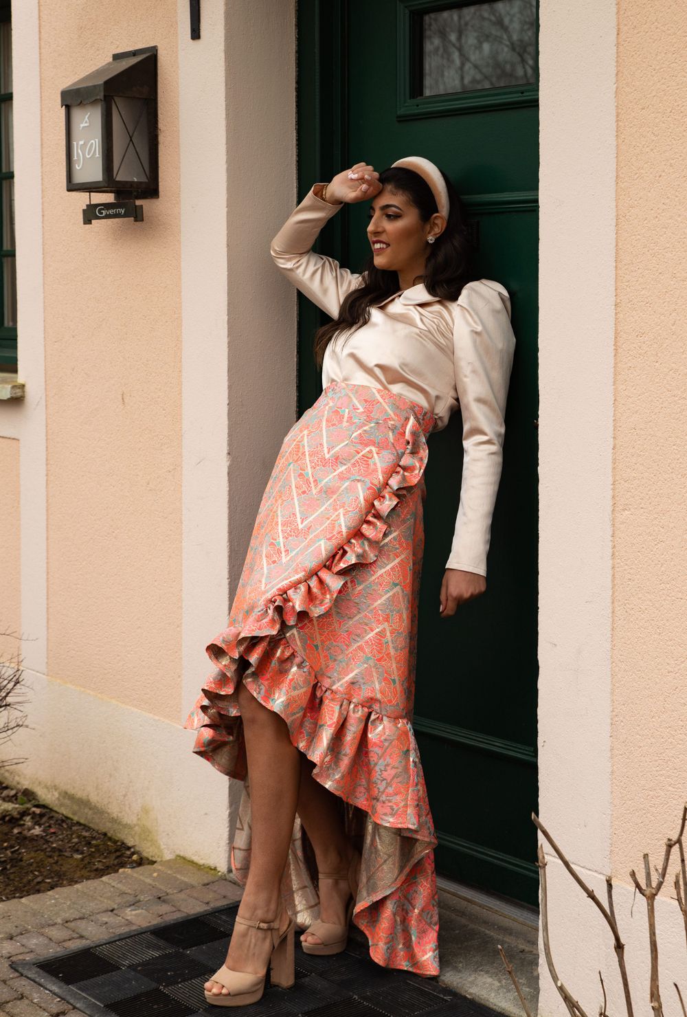 Fashionable outfit featuring pink patterned asymmetrical ruffle skirt and cream blouse by green door.