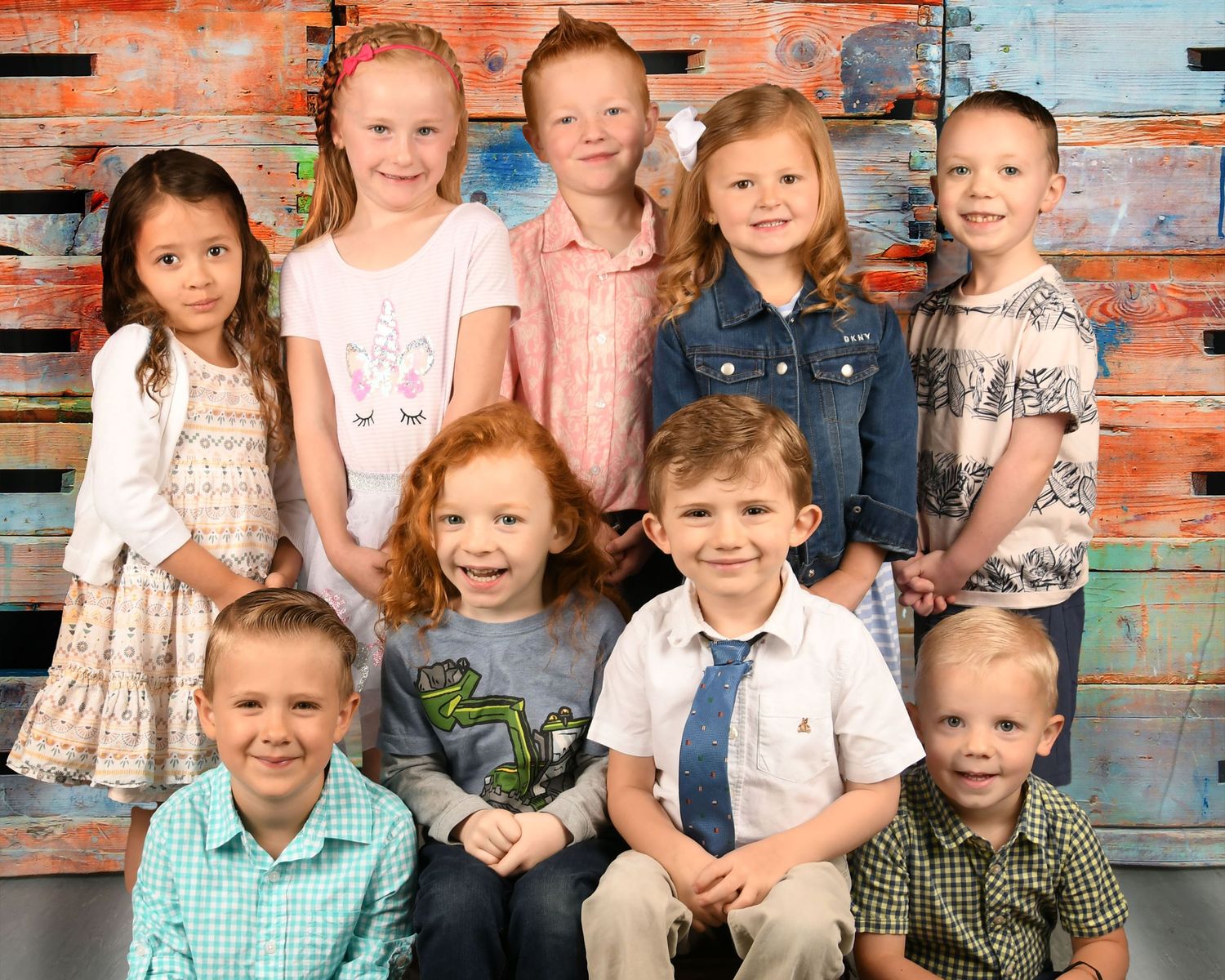 Group portrait against rustic orange and blue wooden wall background.