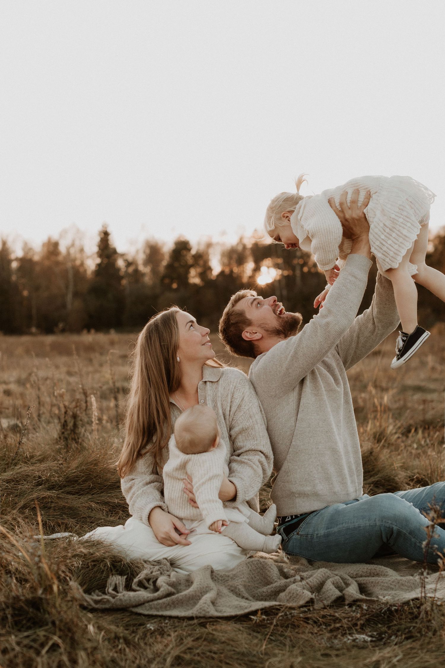 familj fotograferad tillsammans i solnedgången i ulricehamn