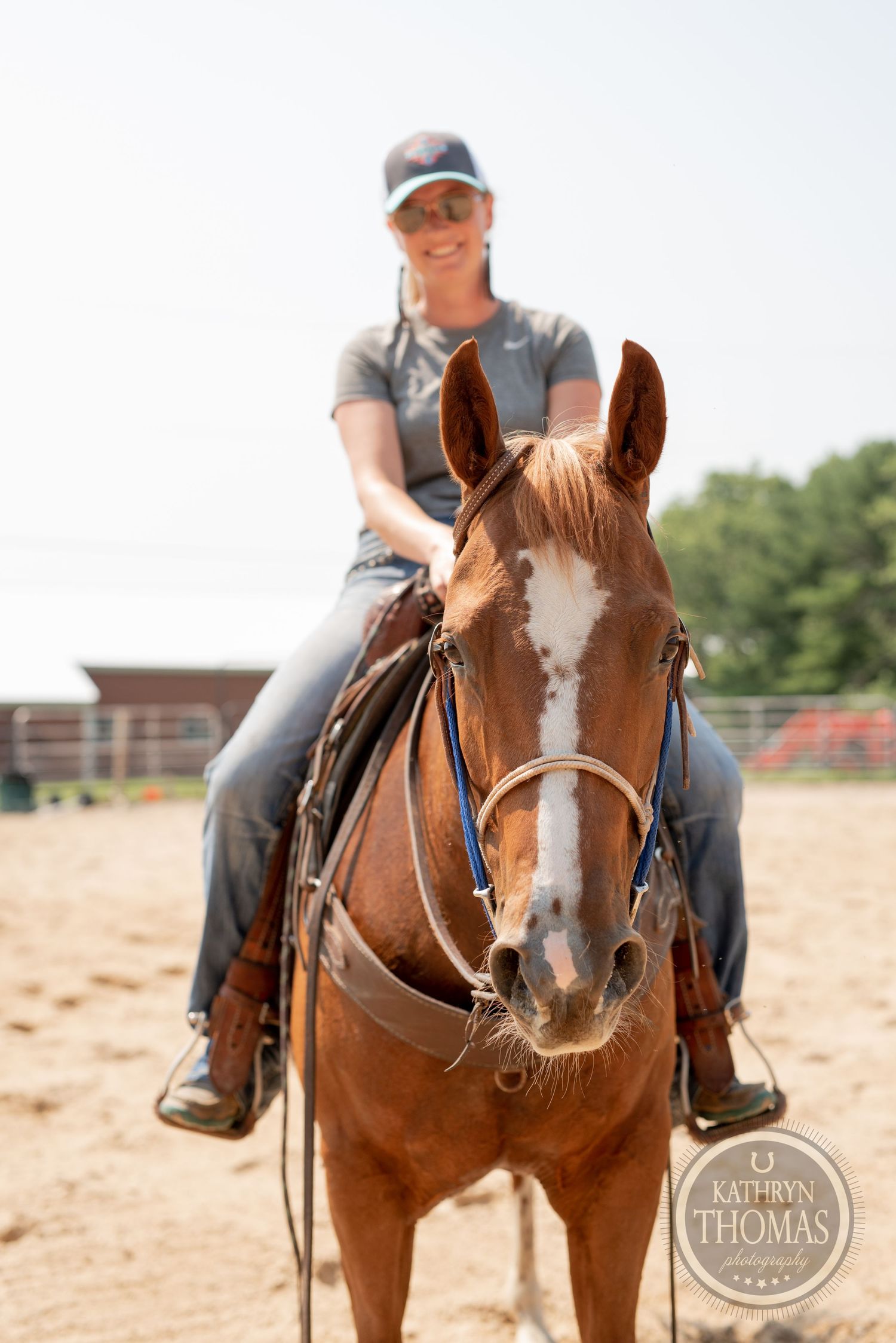 Close-up view of a chestnut horse with white blaze wearing western tack in a training arena.