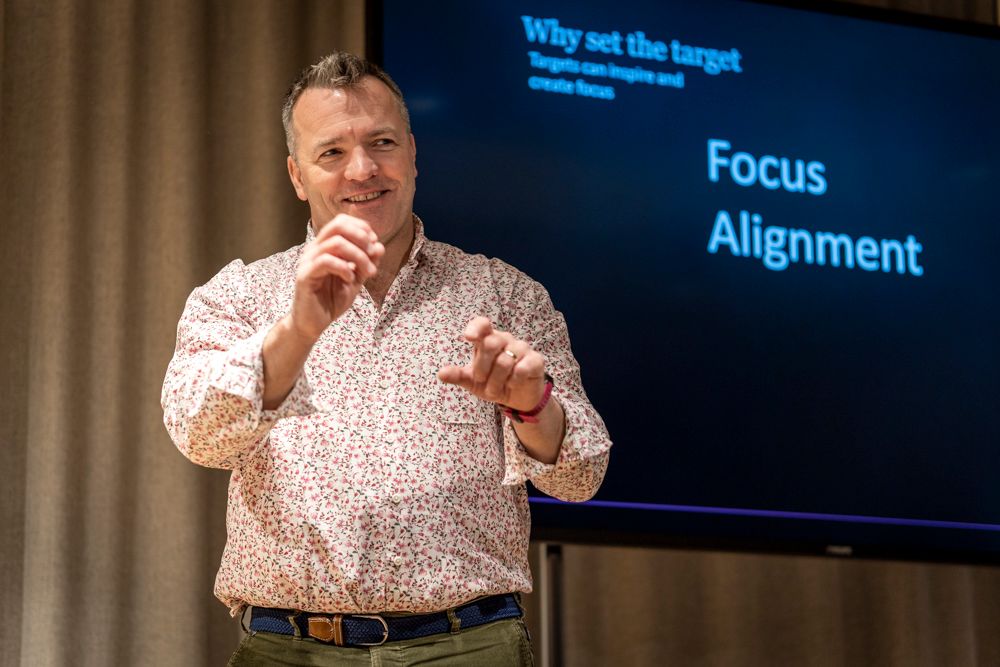 ceo man on stage presenting with patterned shirt