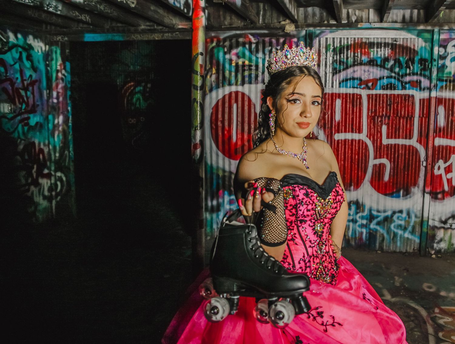 Pink ballgown photographed in an industrial setting with street art and graffiti walls.