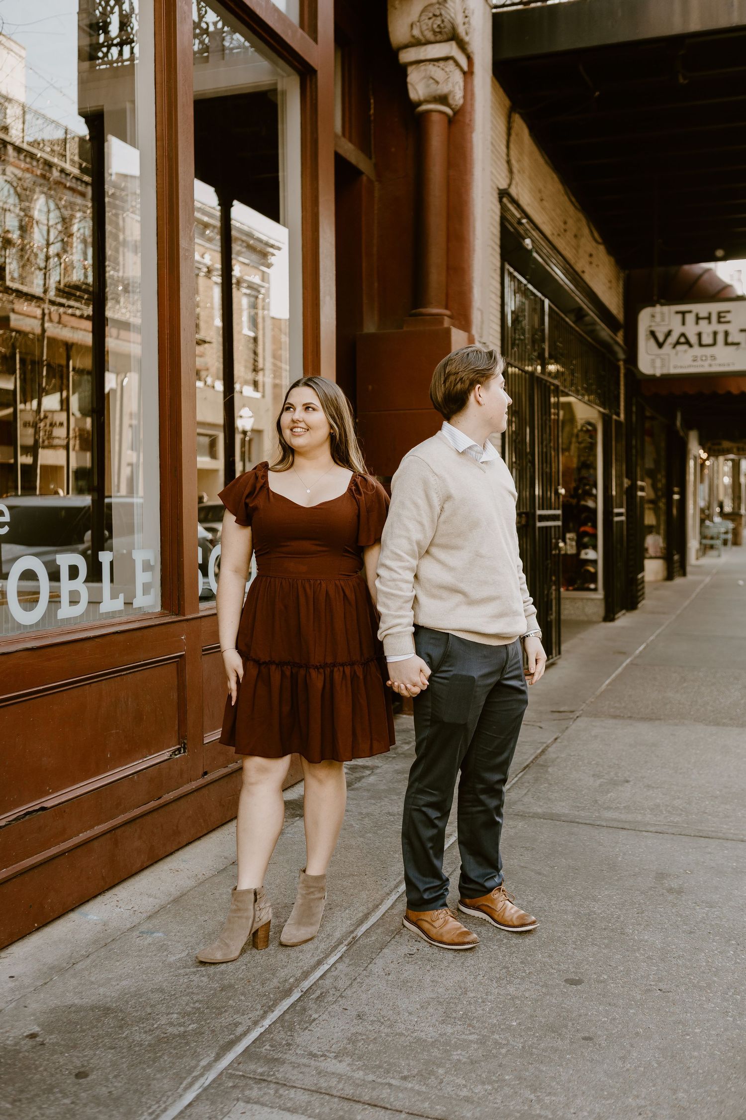 Couple standing on street corner out side of Noble South in Downtown Mobile, Alabama