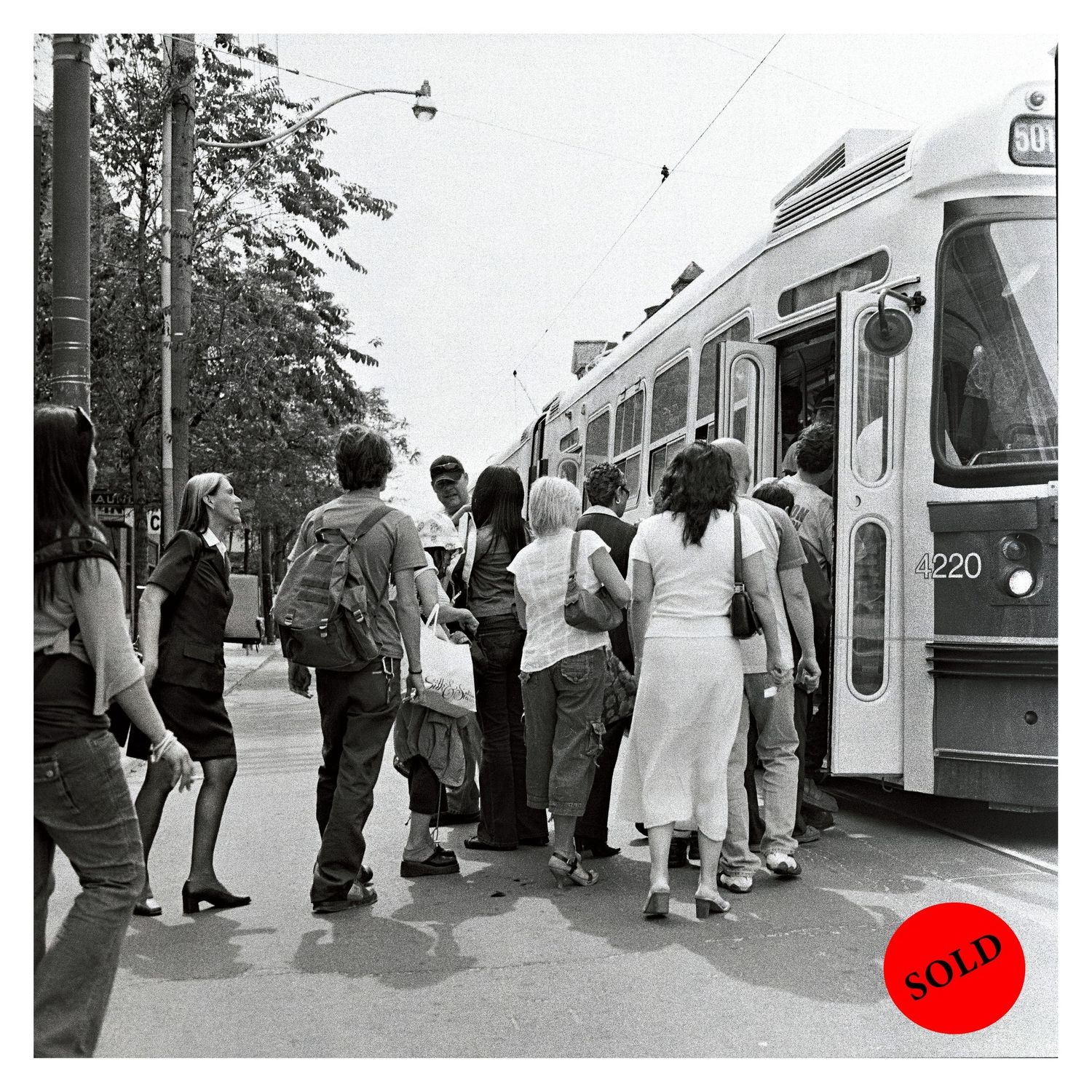 Vintage photograph of passengers boarding a streetcar on a summer day.