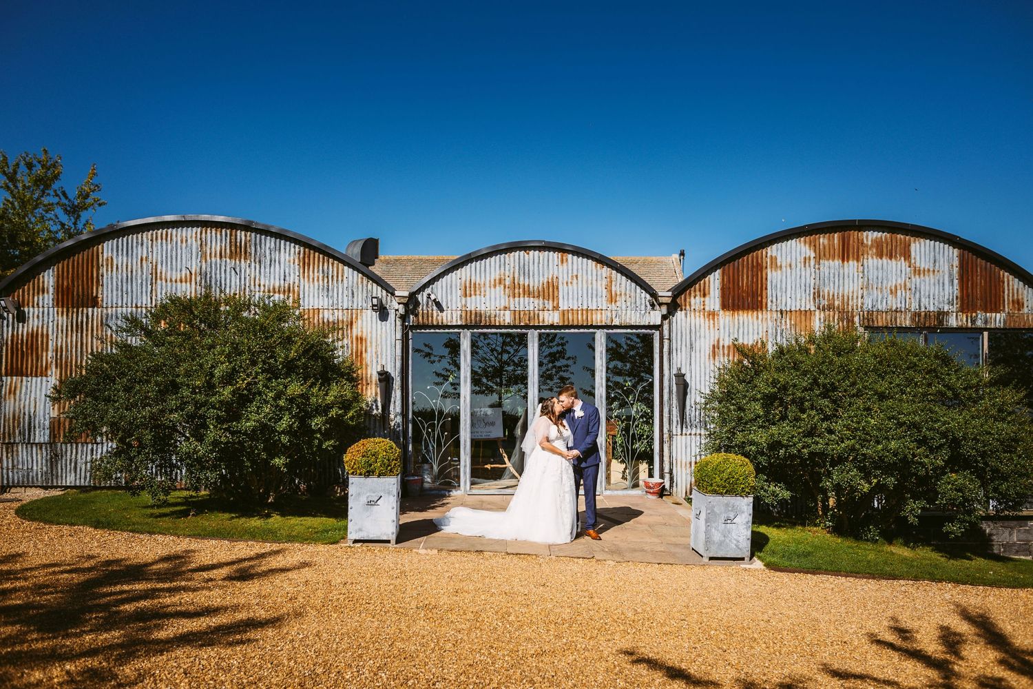 Bride and Groom portrait of beautiful couple Stone Barn blue sky