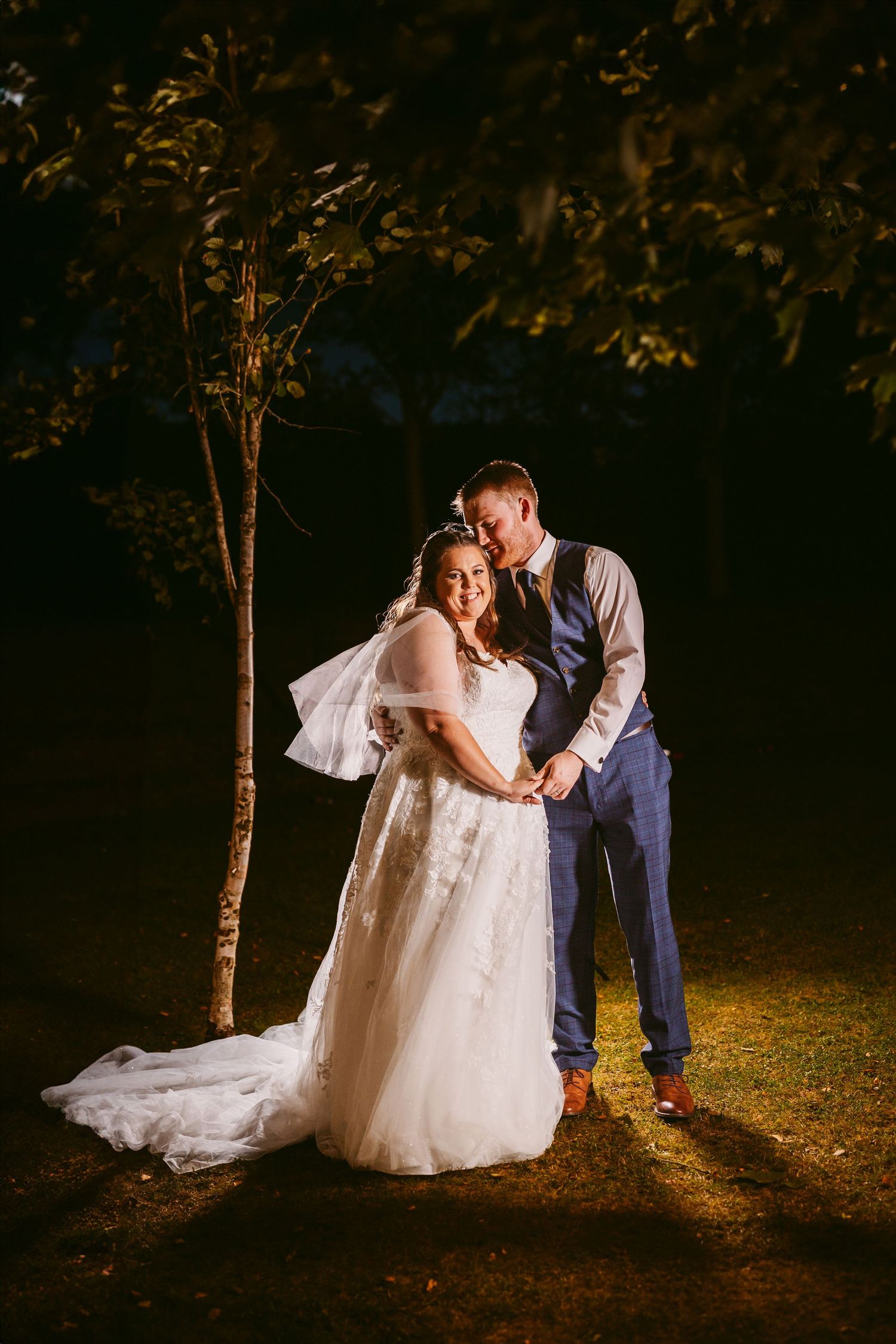 Bride and Groom Portrait in garden at night with pretty lights in trees Stone Barn The Cotswolds