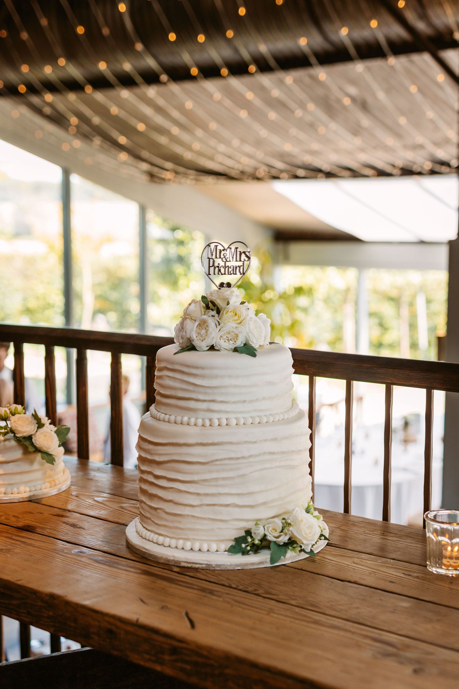 Wedding Cake in Stone Barn with pretty lights behind