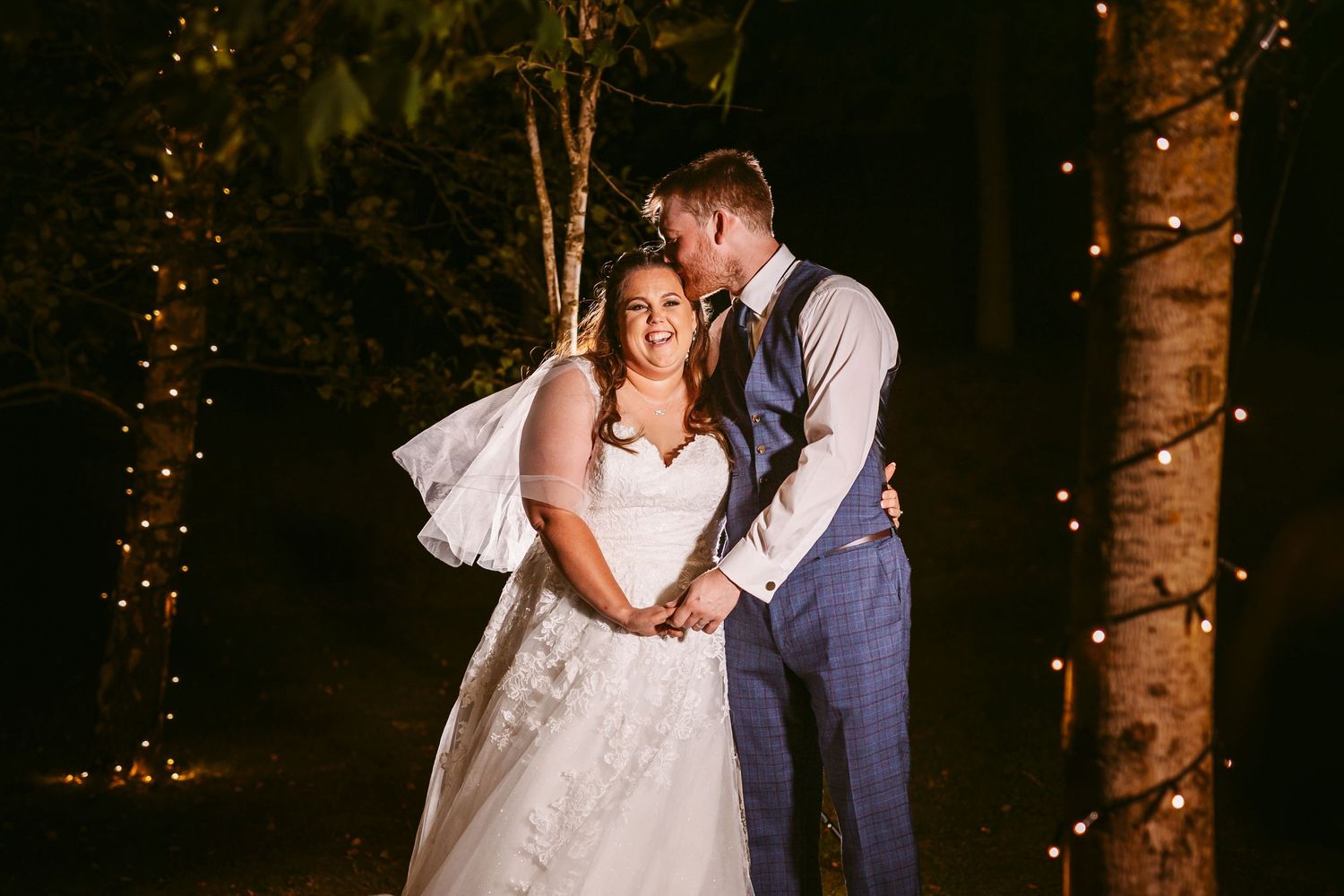 Bride and Groom Portrait in garden at night with pretty lights in trees Stone Barn The Cotswolds