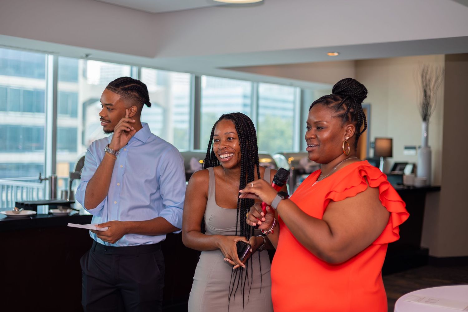 Three guests enjoying drinks and conversation at an indoor celebration event.