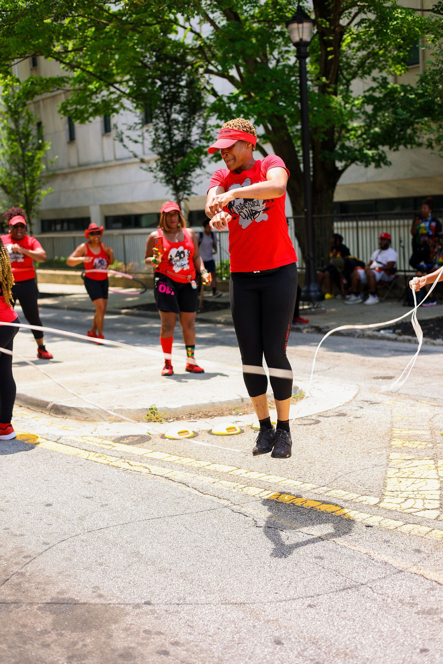 Person in red attire jumping rope during an outdoor fitness event.