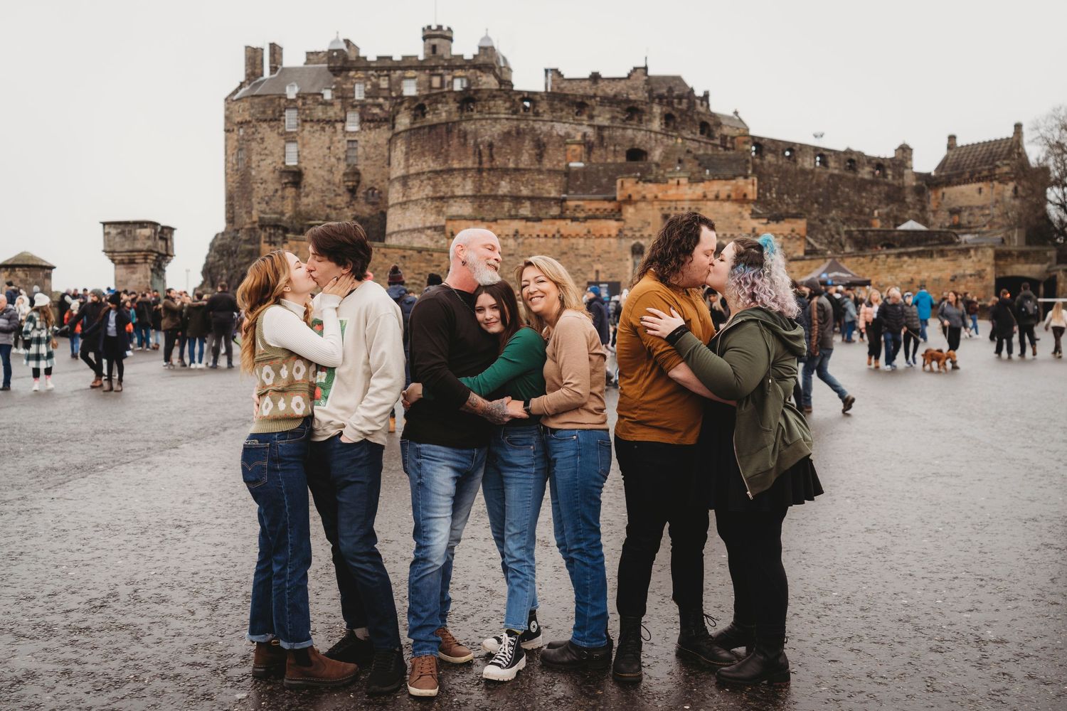 Friends gathered in front of Edinburgh Castle on a crowded plaza.