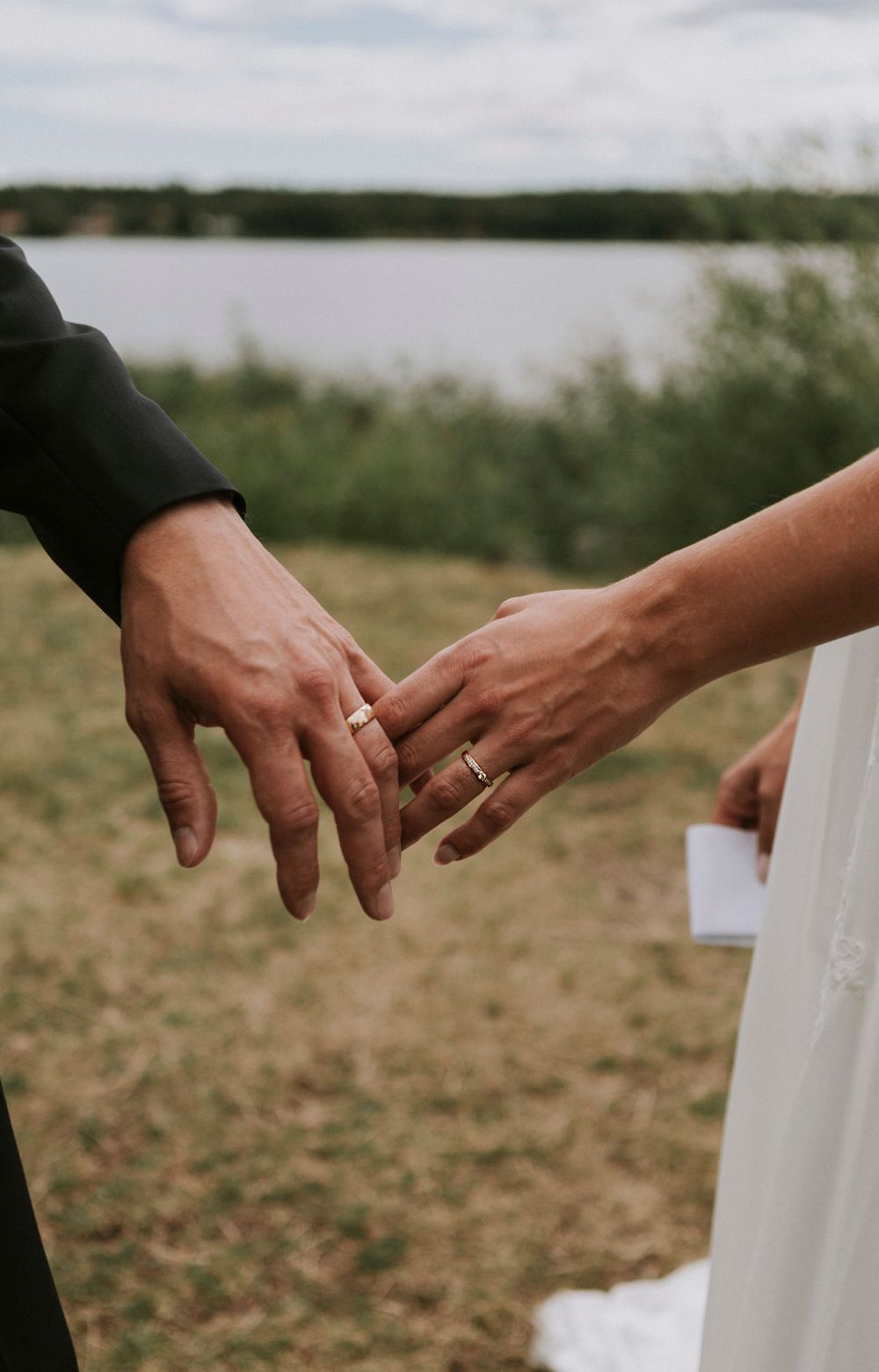 Romantiskt bröllopsfoto på vigselringar och hålla hand