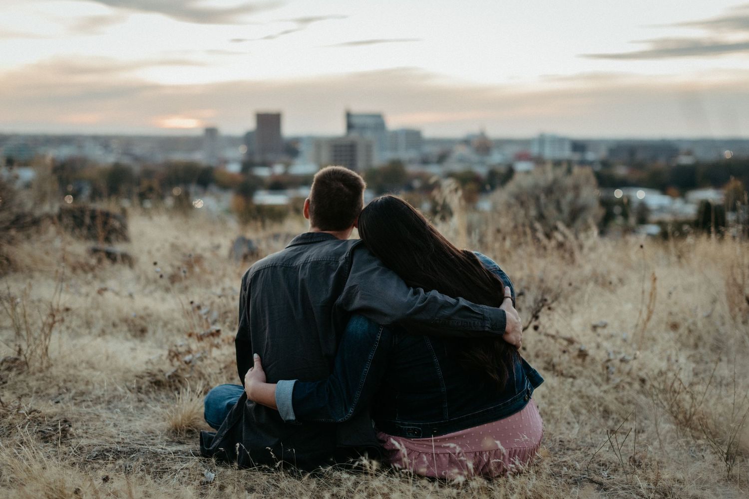 couple hugging while looking at downtown Boise during dusk