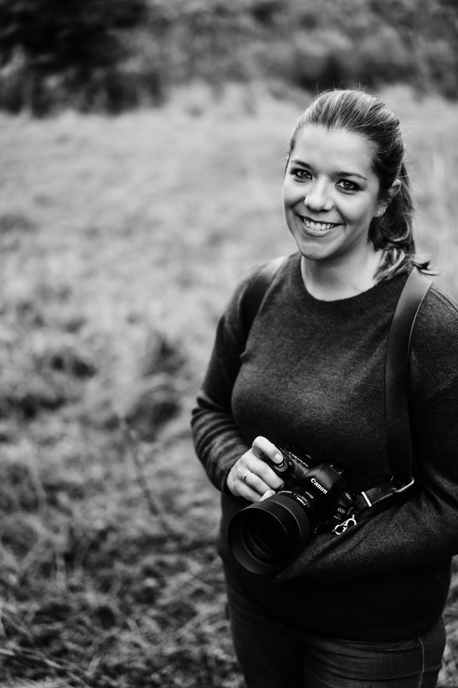 Becky Harley Creative, a brand photographer in Hertfordshire, holding a camera and smiling