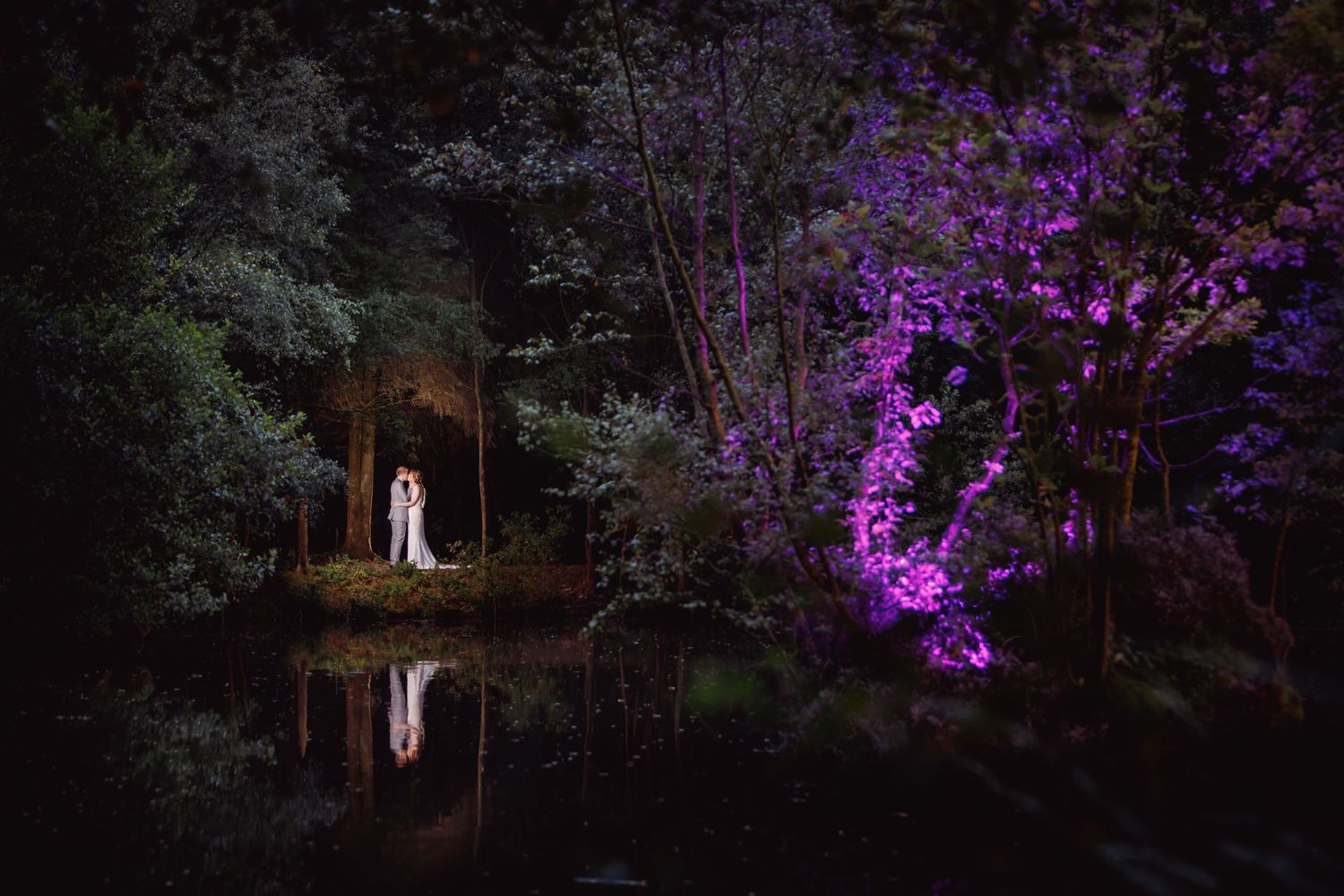 artistic wedding photography looking over the lake at otley chevin country park hotel reflection of the couple over the water