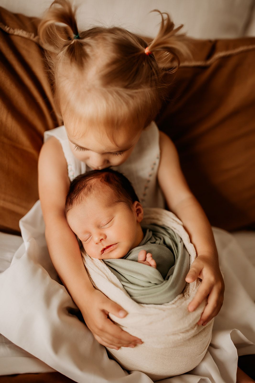 Charlie's older sister holds him in her arms and kisses the top of his head.