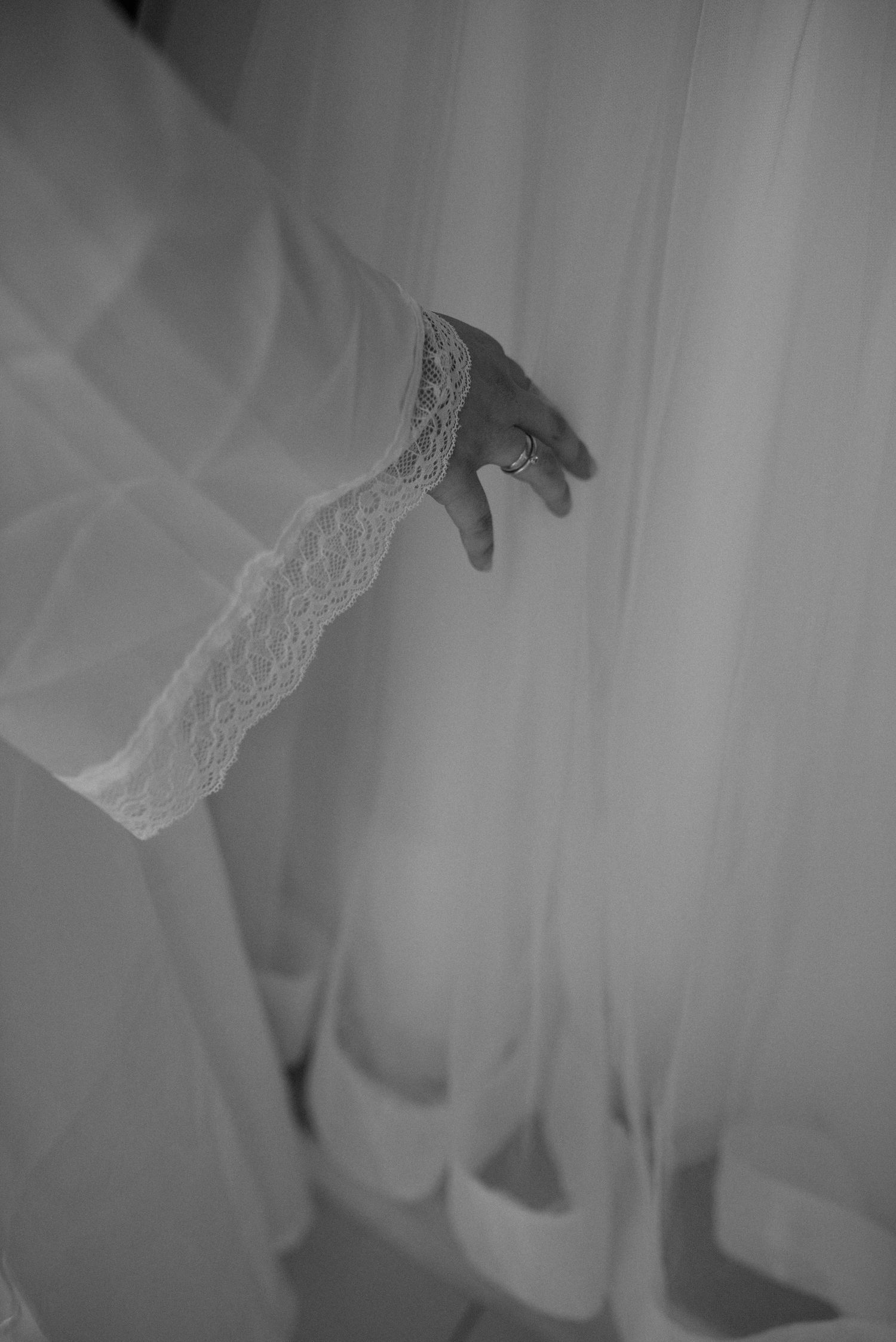 Close-up of a lace-trimmed sleeve detail in black and white photography.