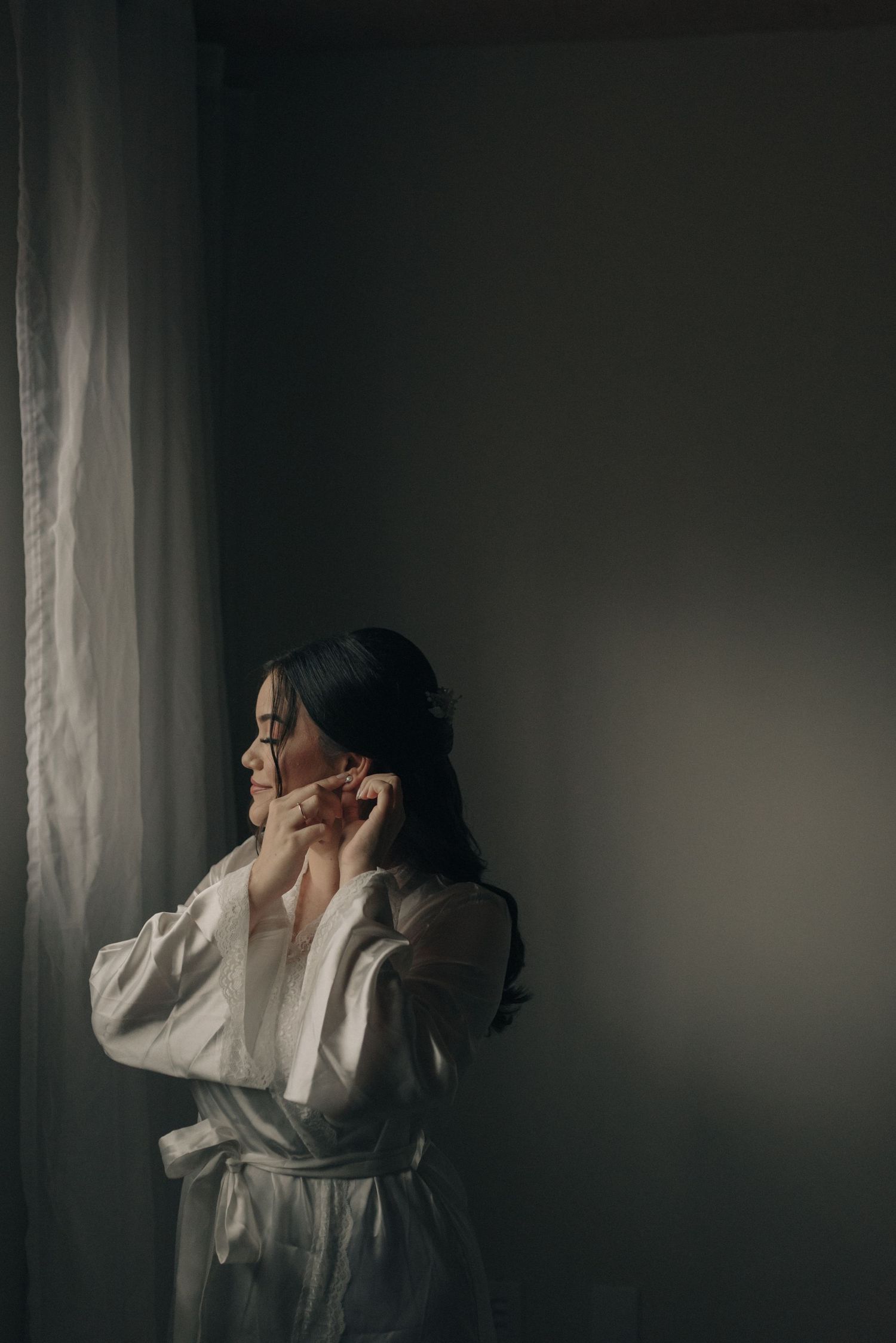 Dramatic side profile portrait by window in natural light.