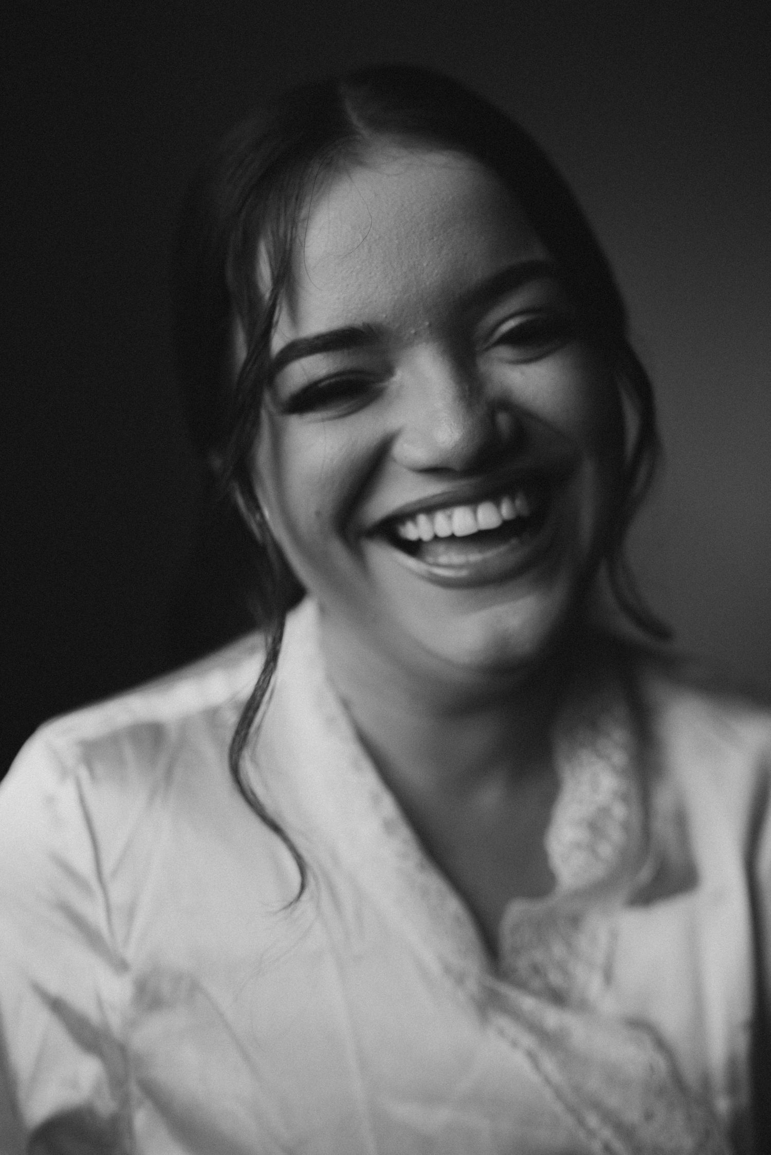 Black and white close-up portrait showing joyful expression.