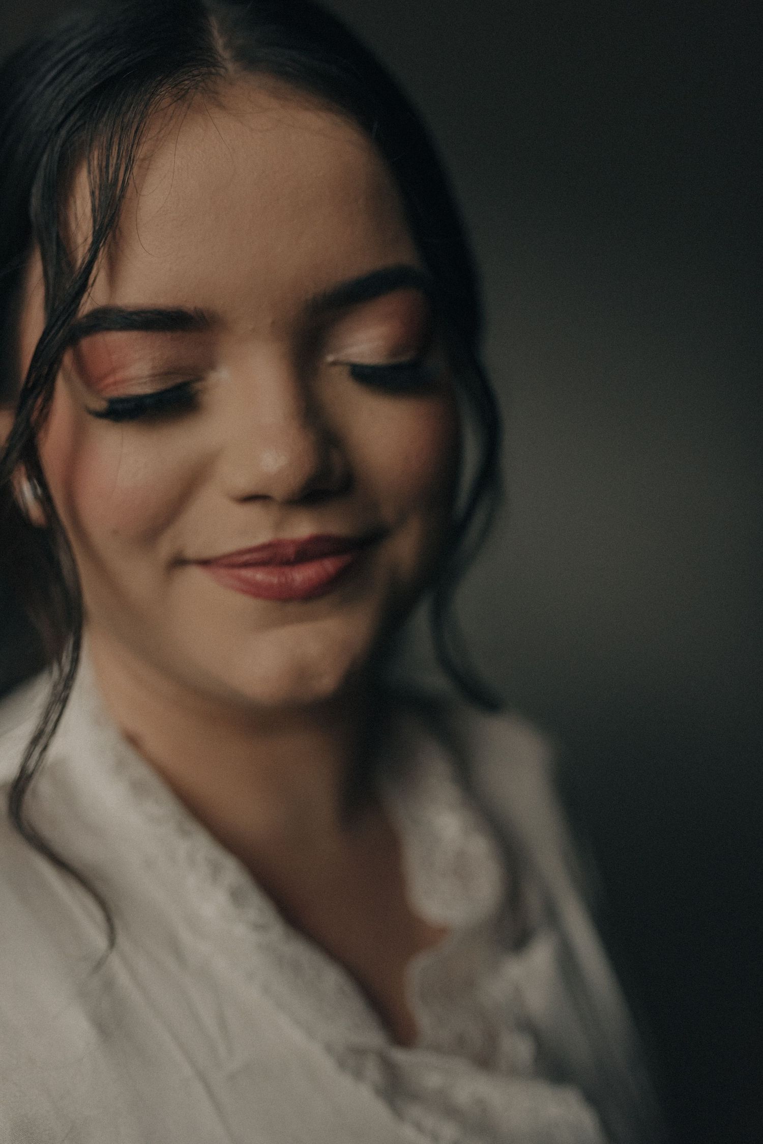 Soft focus beauty portrait with natural makeup and subtle smile.