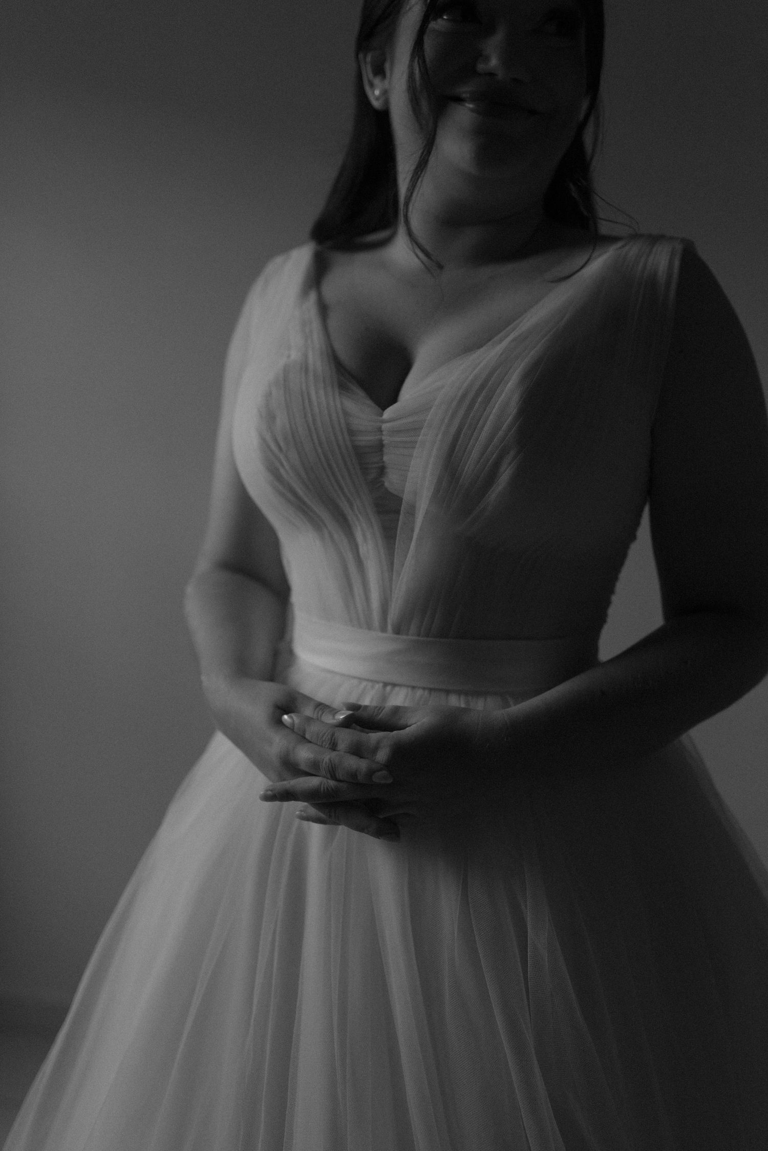 Black and white portrait of wedding dress with structured bodice and tulle skirt.