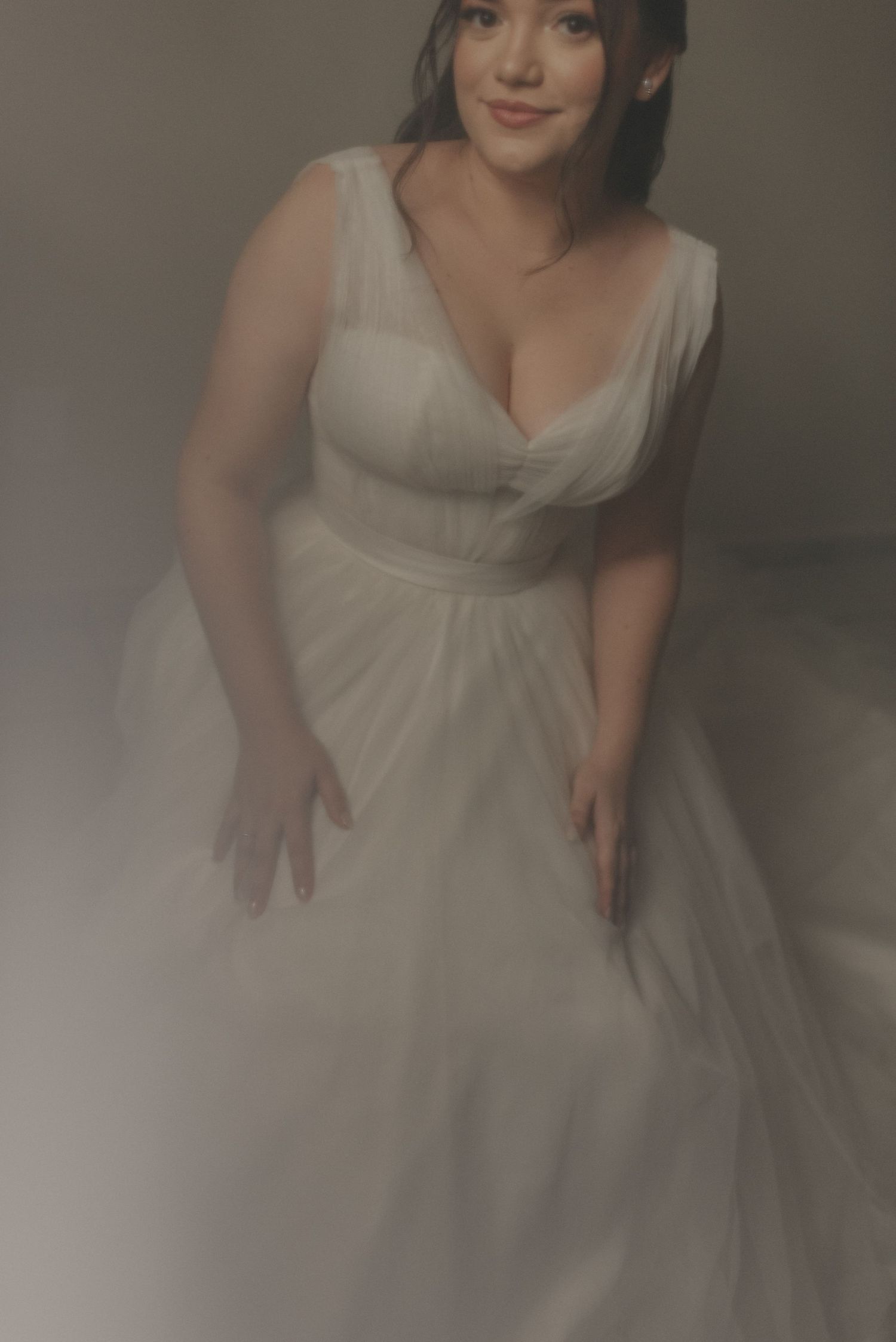 Elegant bridal portrait featuring a flowing white wedding dress with soft lighting and dreamy atmosphere.
