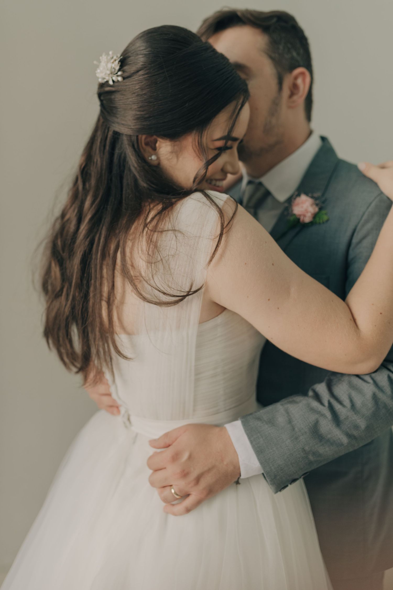 Candid portrait of embracing couple showing emotion during wedding photoshoot.
