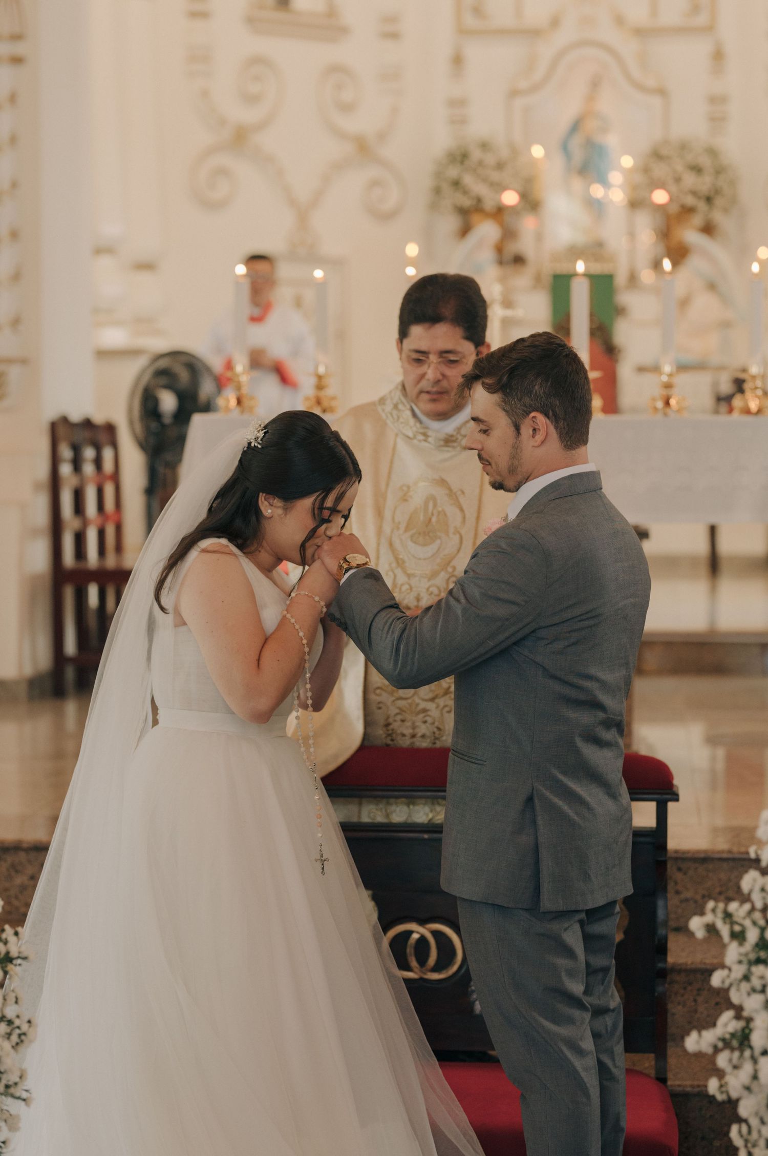 Emotional moment during a Catholic wedding ceremony with ornate altar decorations.