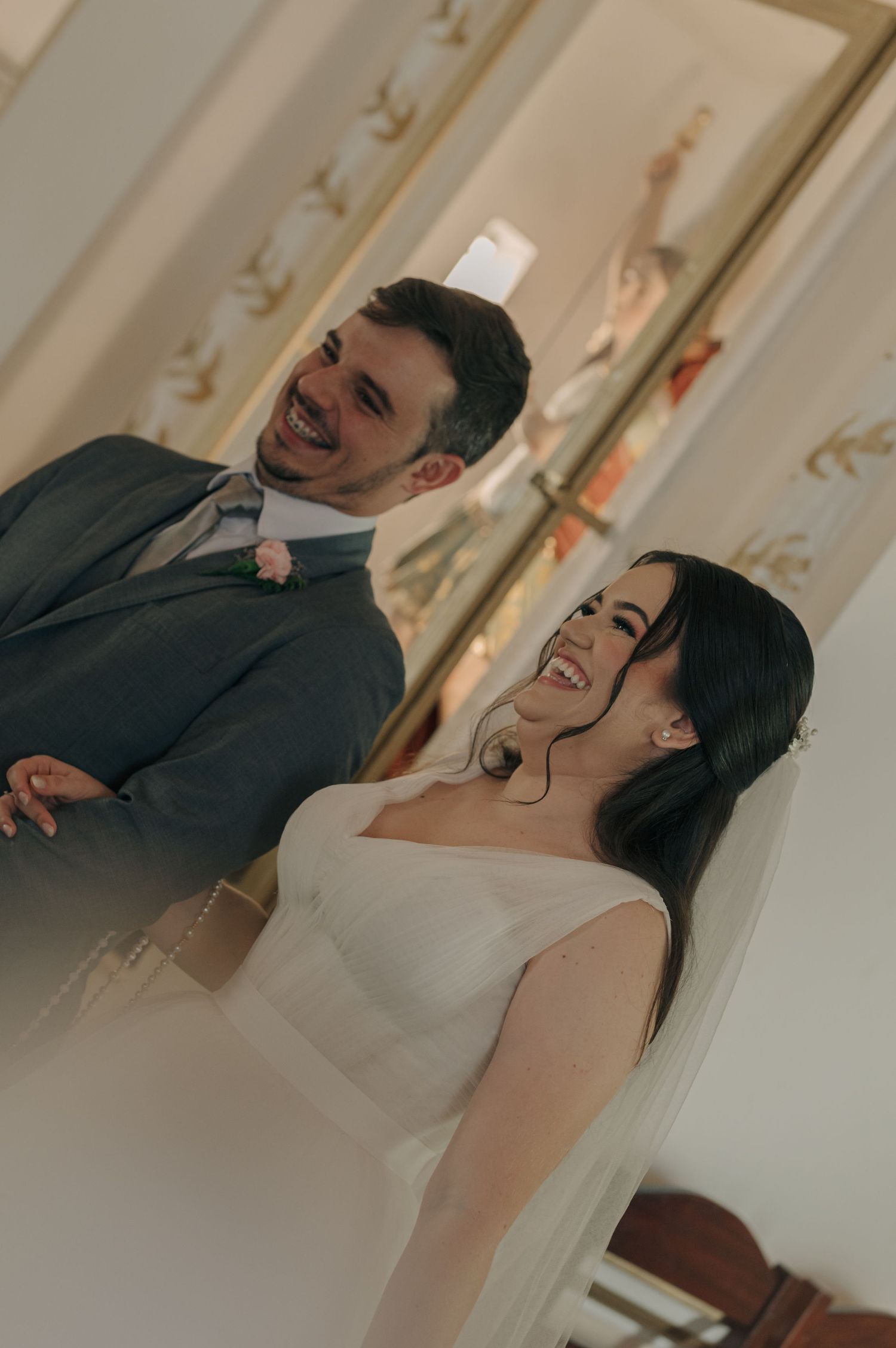A couple shares a joyful moment laughing together during their wedding day celebration.