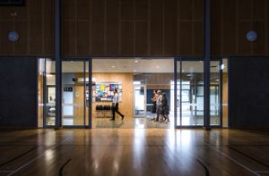 Modern office building entrance with glass doors and reflective floor.