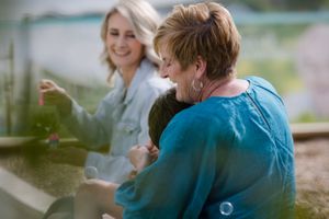 People sharing a joyful moment together outdoors on a sunny day.