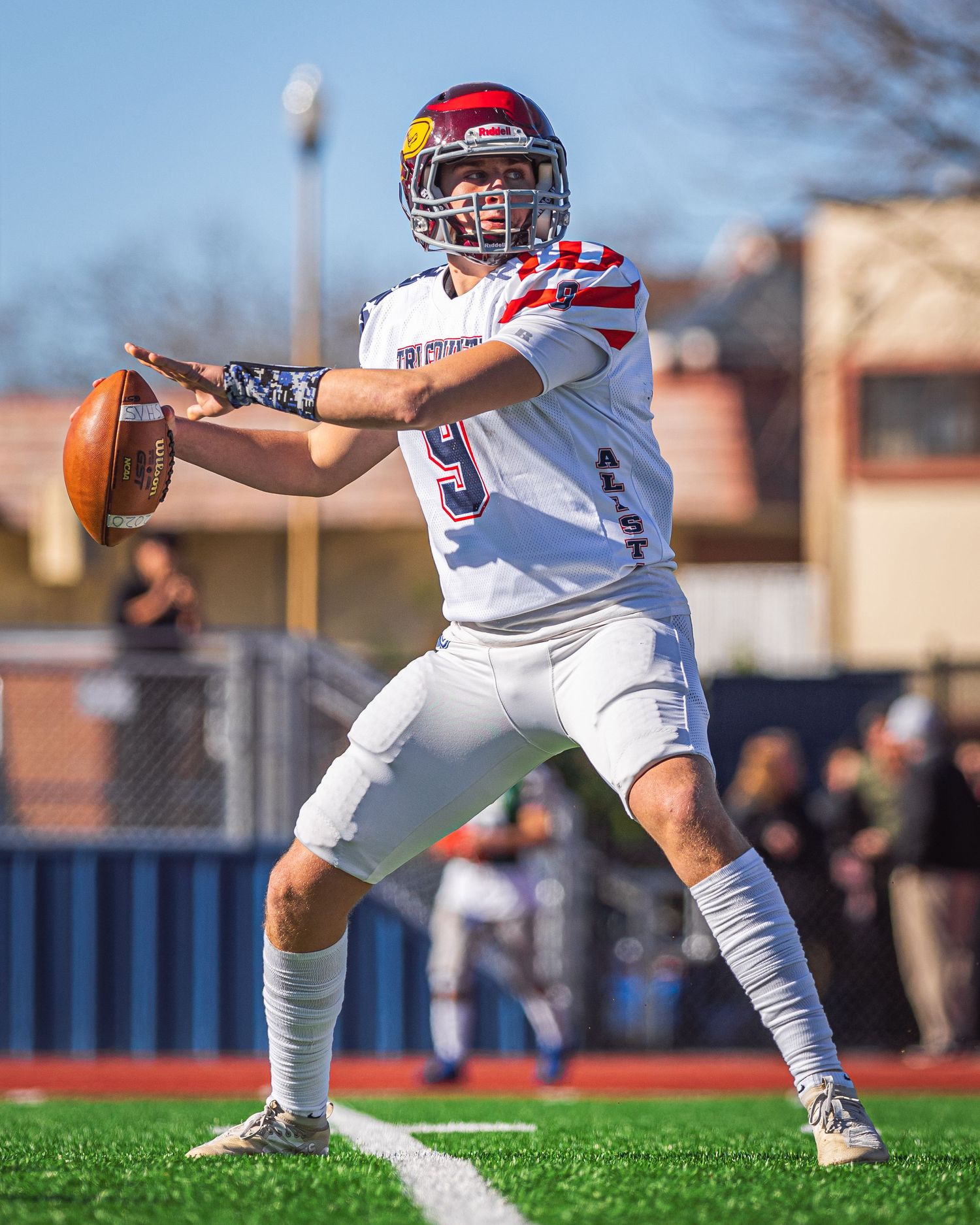 Football player in white uniform prepares to throw pass during game.