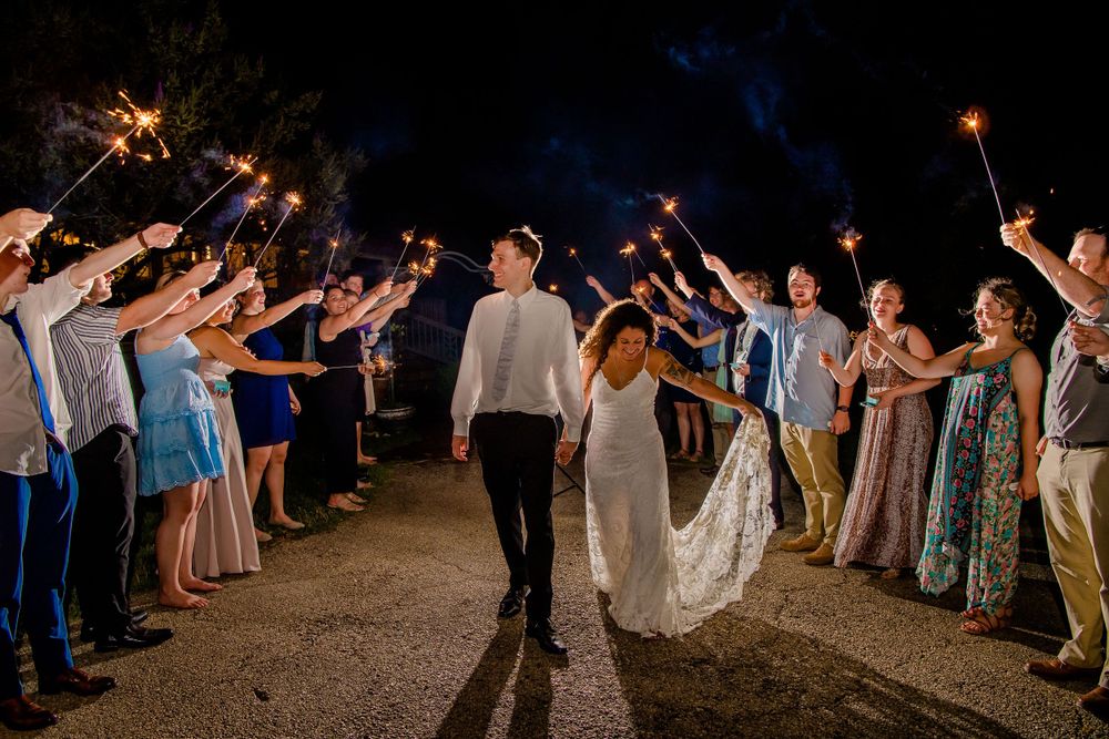 Wedding sparkler exit with guests lining pathway at night.