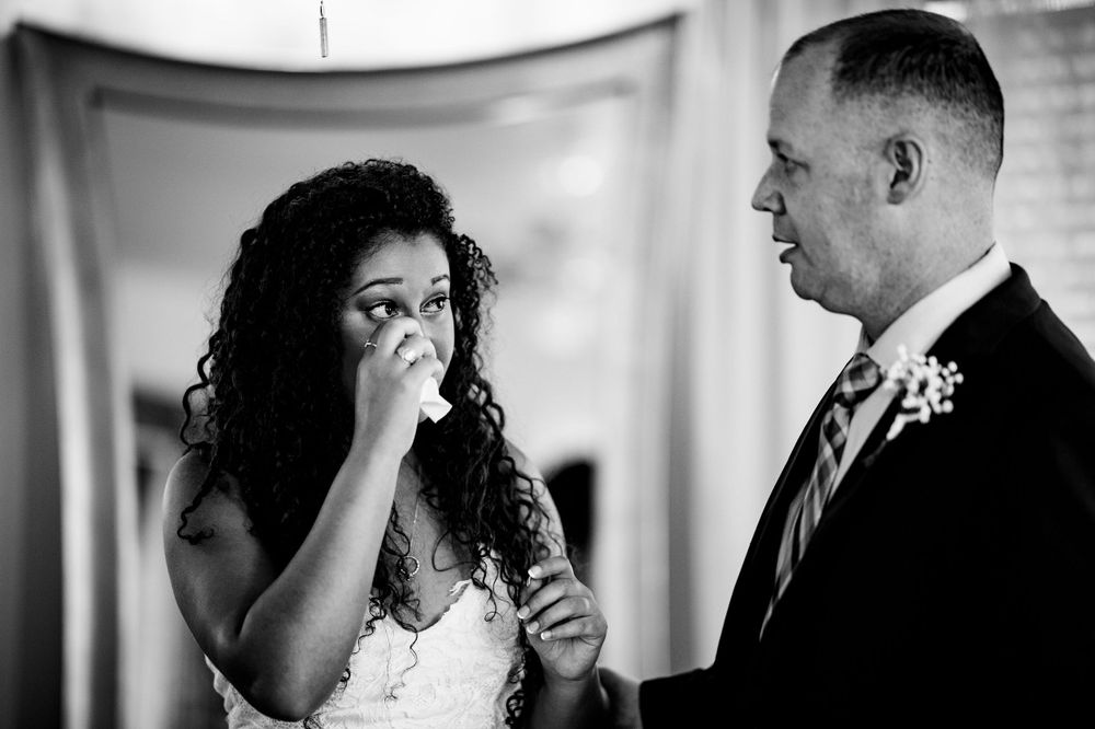 An emotional moment captured in black and white during a wedding ceremony.