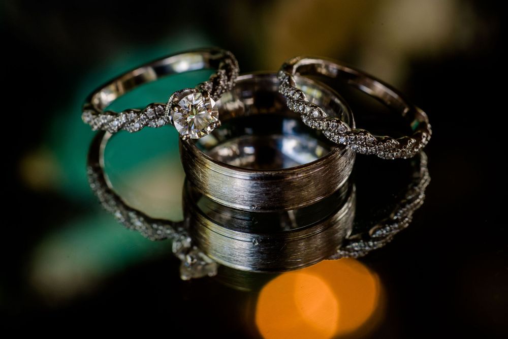 Wedding rings and diamond bands arranged artistically with bokeh lighting effects.