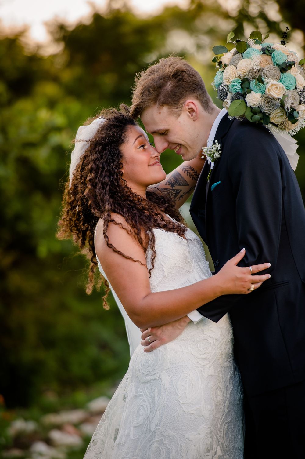 Romantic sunset golden hour portrait of newlyweds with floral arrangements.