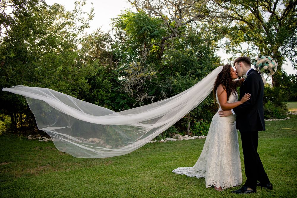 Elegant wedding portrait with flowing white veil gracefully billowing in the breeze.