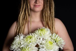 A dramatic studio portrait showcasing white chrysanthemums against a black background.