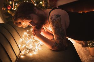 Person lying with string lights creating warm ambient glow against dark background.