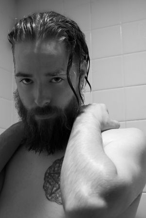 Black and white bathroom portrait showing wet hair and beard.